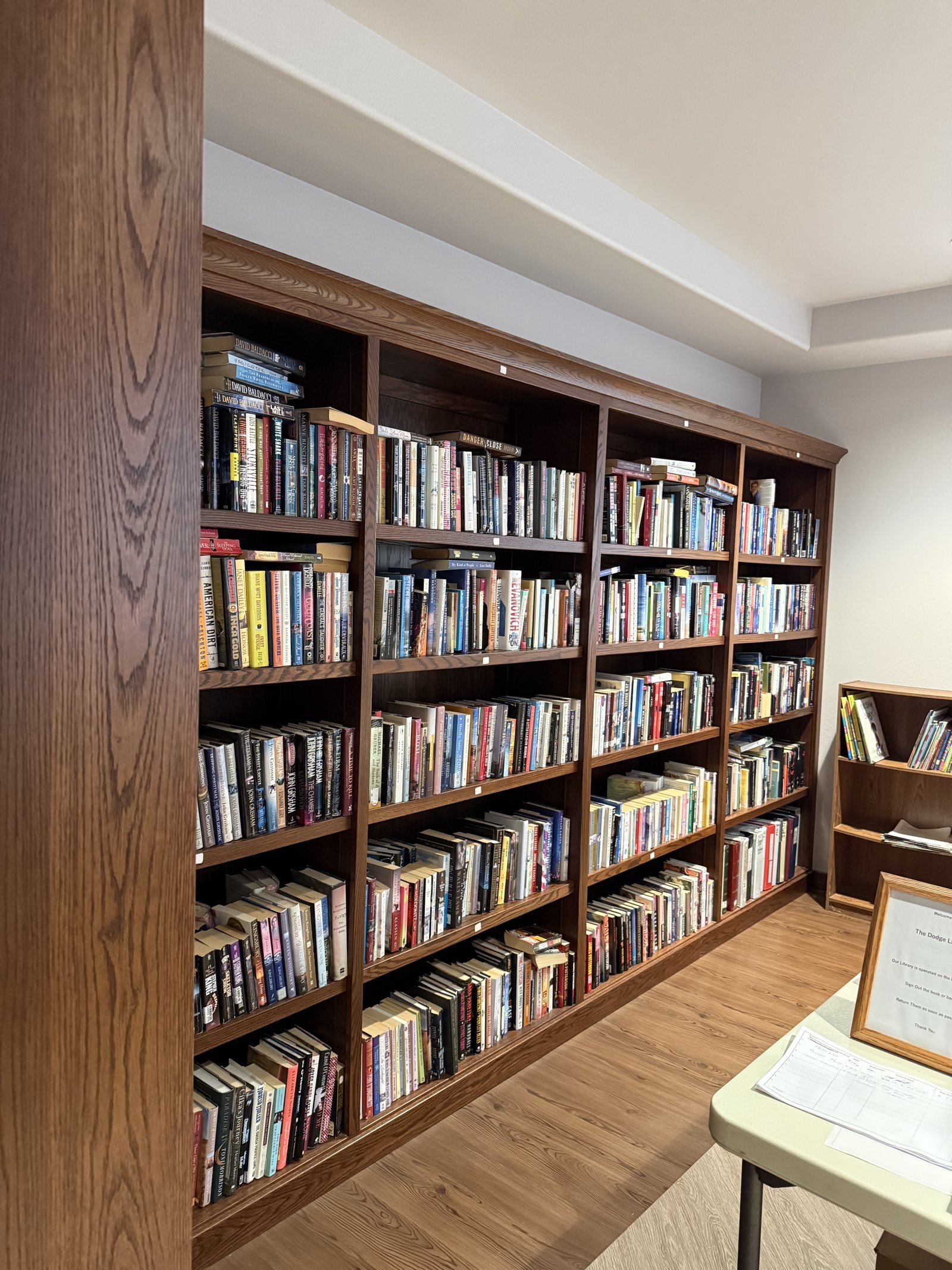 Floor-to-ceiling wooden shelves filled with books along the wall of the Dodge Library